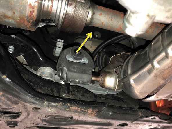 Pull the rubber hanger on the OE front-pipe free from the hanger rod on the chassis in the direction shown