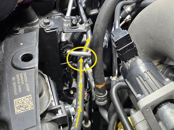 Route the OE coolant hose underneath the AC hard line towards the coolant tank as shown