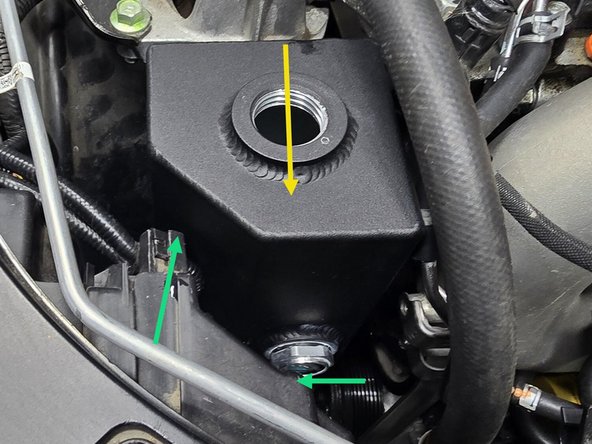 Carefully insert the 27WON coolant tank into the engine bay as shown