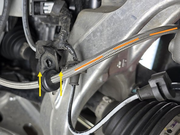 Route the brake line behind the hub and over the CV axle as shown