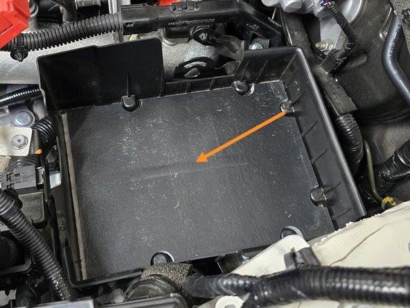 Place the plastic battery tray into the engine bay in the orientation shown, the plastic alignment pin on the bottom will slot into the hole circled in the last step
