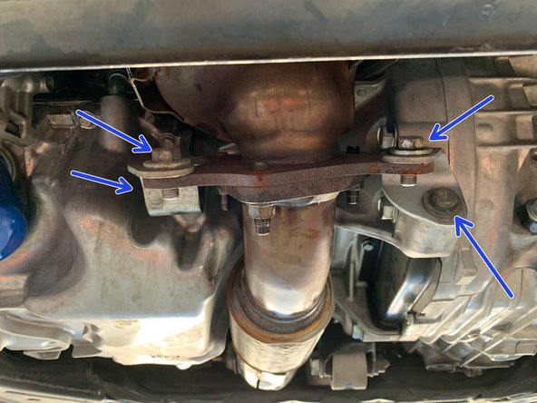 Using a 14mm socket and a 14mm wrench , undo the (4) bolts for the downpipe brackets as shown