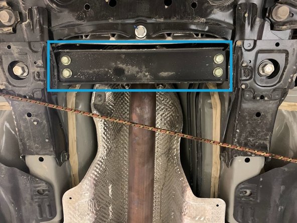 Using a 6 inch extension, and a 17mm socket tighten down the hardware connecting the front pipe and mid pipe as shown