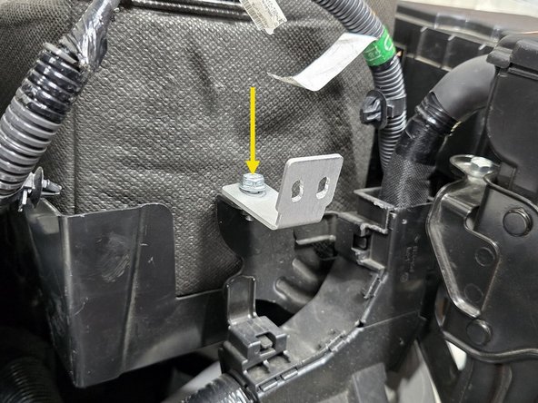 Using the 20mm bolt previously securing the ECU mounting bracket, secure the upper battery bracket in the location shown