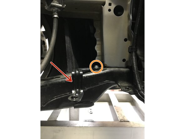 From under the vehicle, locate lower airbox assembly mounting bracket