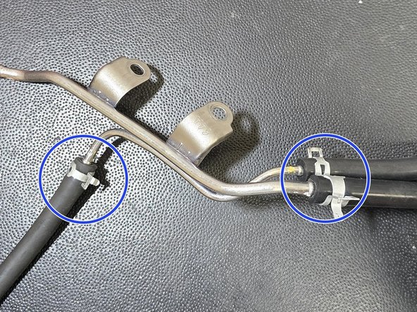 Remove clamp as shown and replace hose with cut piece of silicone hose