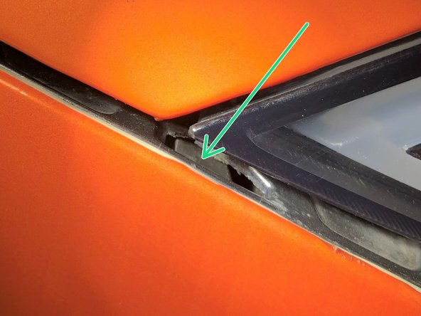 Keep pulling outward on the bumper and use a plastic interior trim tool to release the bumper from the three retaining clips by pushing on the retaining clips