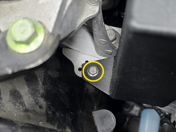 Thread the provided M6x12mm bolt through the mounting hole on the back side of the coolant tank into the chassis as shown