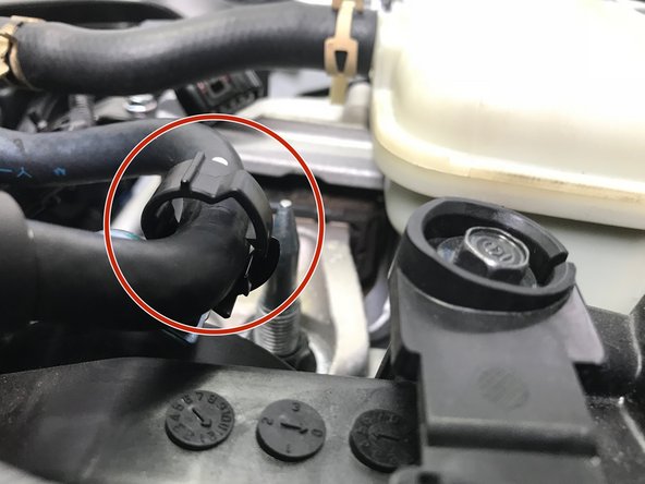 Reinstall the plastic clip holding the upper coolant hard lines and rubber hose