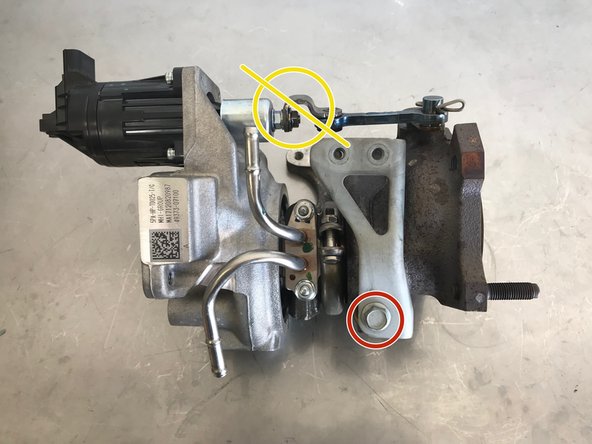 Use a 12mm wrench to remove the bolt holding the bracket shown