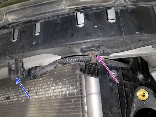 Use pliers to disconnect ambient temperature sensor from cover. Pull cover slightly off bumper to access loom clip as shown. Remove clip with pliers