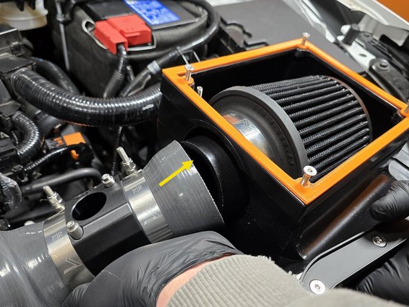 While lowering the airbox into the engine bay, press the airbox silicone onto the airbox as shown