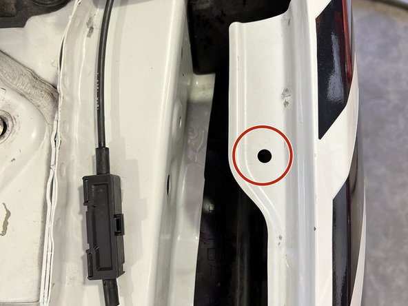 Locate small 5mm hole on driver-side fender. Place supplied Riv Nut in hole with red circle
