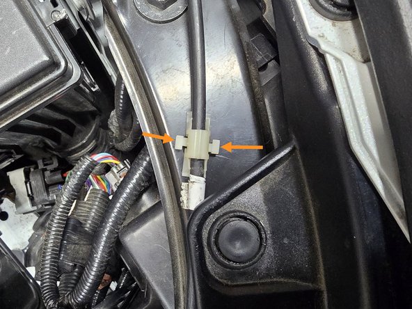 Tuck the wire under the headlight mounting plate as shown