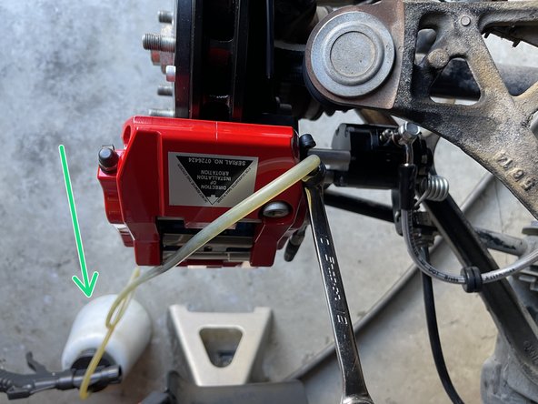 Place the box end of the 10mm wrench over the bleed screw hex as shown