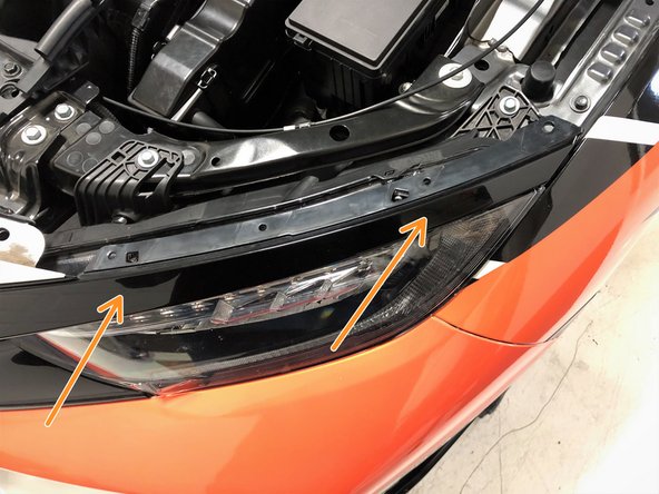 Position the upper headlight trim just above the headlight and gently push it inward to connect the two clips to the headlight