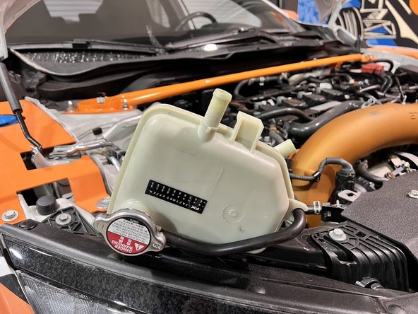 Use caution not to break coolant tank. Hose pliers are useful here