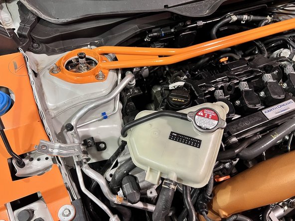 Move coolant tank up and out of the chassis brackets as shown