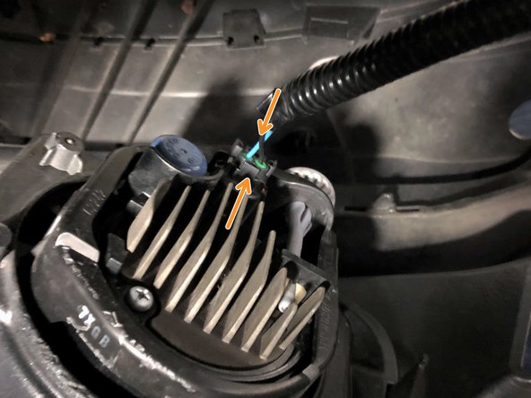 Reach between the bumper and the rest of the vehicle. Unplug the fog light by squeezing the top  and bottom of the plug