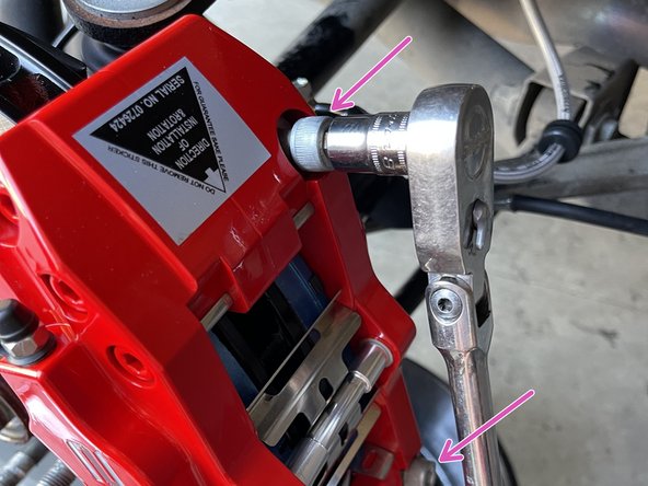 Install the caliper on to the caliper bracket as shown