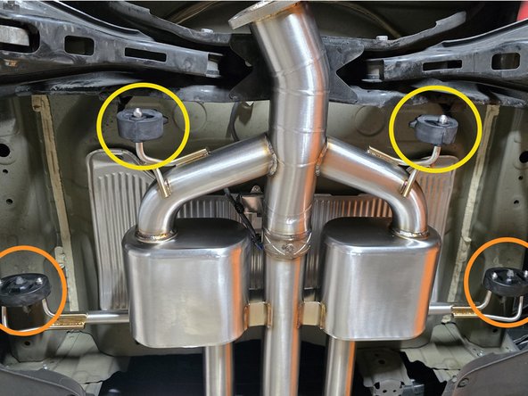 Press the forward exhaust hangers onto the axle back studs as shown