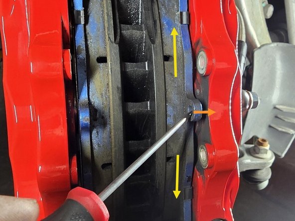 Using a 90deg pick tool, hook the pick on the removal ring of the brake pad and pull it straight out of the caliper