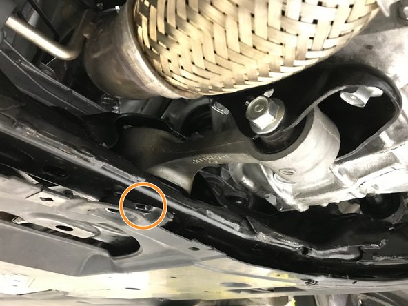 Using a 17mm socket and breaker bar, loosen the chassis end RMM bolt indicated with orange circle