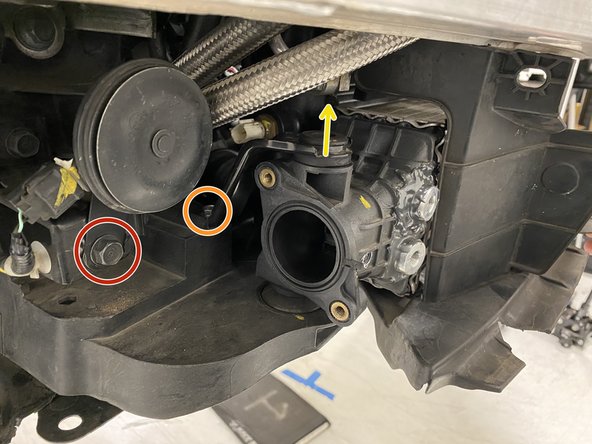 Remove the 12mm bolt from the OEM horn on the passenger side of the vehicle using a 12mm socket and ratchet