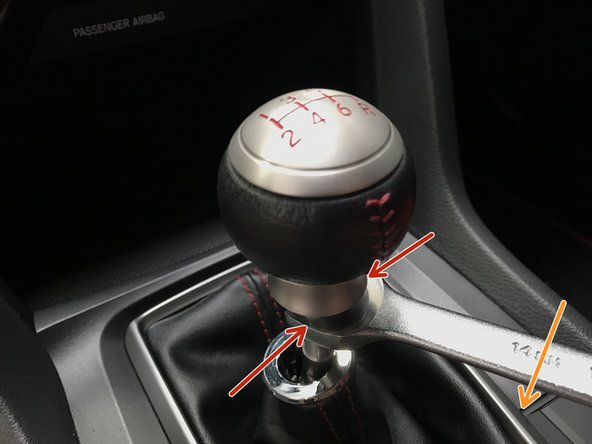 While holding the shift knob, use a 14mm wrench to loosen the locking nut