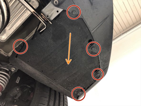 At the rear passenger side of the vehicle, remove the five push clips that hold the rear bumper fender liner to the rear bumper