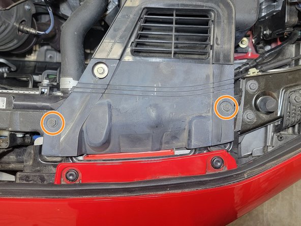 Use a 10mm socket and 3/8&quot; ratchet to remove the two (2) bolts securing the rubber shroud