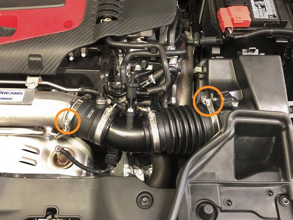Using the 5.5mm socket and ratchet, loosen the two OEM clamps securing the intake tube