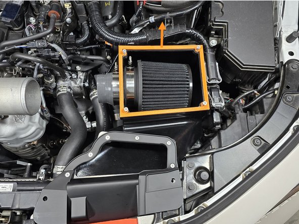 Firmly lift the back side of the airbox to pop the lower bracket off of the mounting bushing