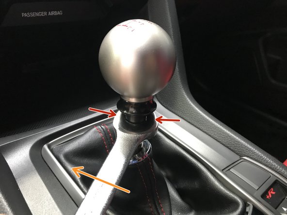 While holding the shift knob, use a 14mm wrench to loosen the locking nut