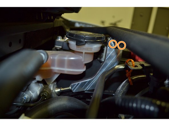 Insert the brake brace into the tabs and align the holes in the brake brace with the holes in the mounting tabs