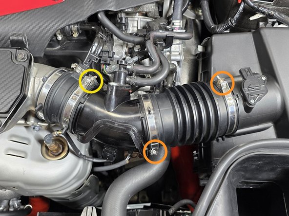 Use a 5.5mm socket and 3/8" ratchet or a small Phillips screwdriver to loosen the two intake clamps circled in orange