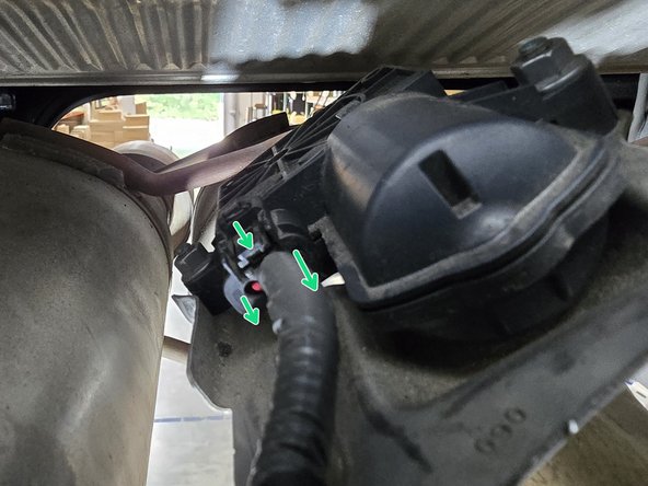 Following the wire to the top of the exhaust to the valve motor, use your hand to press the release tab on the top of the plug and pull it free from the motor