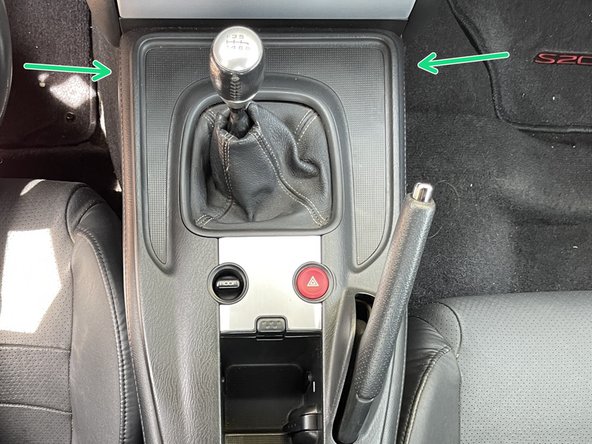 Start in the back corner and work your way around the center console and using your hands, unclip the retainer clips from the transmission tunnel by pulling up with mild force