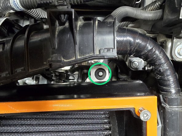 Press airbox down to mount the lower bracket over the bushing as shown