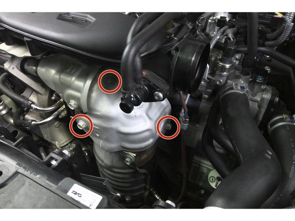 Use a 12mm ratcheting wrench to remove the three (3) x 12mm bolts securing the upper heat shield to the factory downpipe