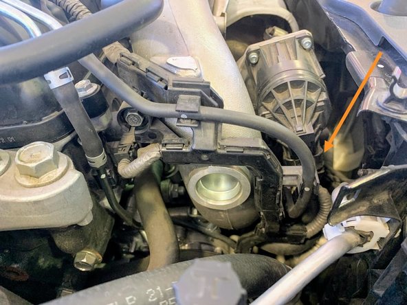 Unplug the wastegate actuator by pressing the tab shown, and pulling the plug downward