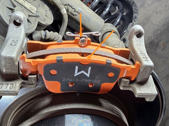 Install the inner and outer brake pads into the caliper bracket as shown