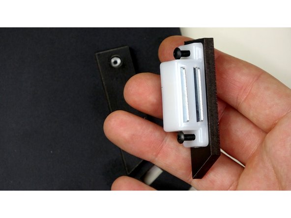 Insert two, 16mm bolts into the magnetic catches, one on each side. Then place the Top standoff bracket below the magnetic catch, making sure to bring the bolts through as pictured.
