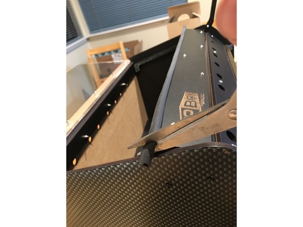 Lay the box on its back and peel the backing off of one of the strips of gasket.