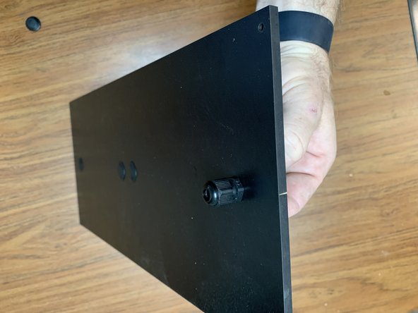 Remove the Exit Fitting (Part 25) from Parts Pack C and remove the end nut. Slip the fitting through the Rear Panel's remaining open hole and fasten it with the nut on the opposite side of the panel as shown in picture 3.