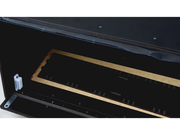 Insert the Center Track Guide panel into the tab holes of the mounted side panel.