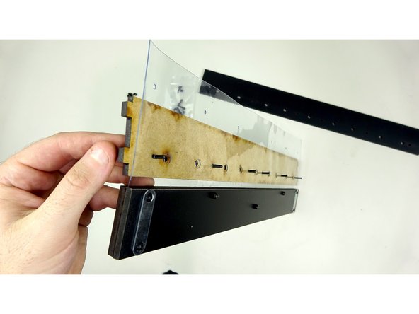 With everything face down (logo  down), place the Outer Exit Plate (the one WITH tabs) under the vinyl sheet as pictured.