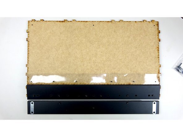 Flip the Base panel over to where the unfinished side is  facing up, being careful to keep the 4 inserted bolts and Steel support beam in place underneath. There should be enough bolt sticking up through the top of the Base panel to complete this step.