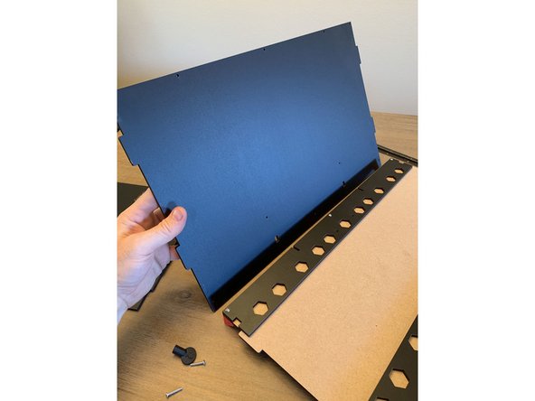 Using three 16mm screws, fasten the rear panel to the base panel with the finished side of the rear panel facing forward as shown in pic 1. The bottom of the rear panel is the side that has the two  square notches cut into it.