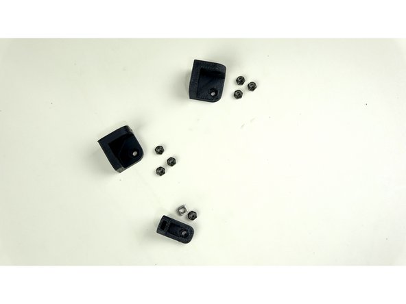 For this step you'll need the two 3D printed corner brackets and the last L bracket. You'll need 3 nylock nuts for each corner bracket, and a nylock nut for the L bracket. You will also need one square nut for the L bracket.